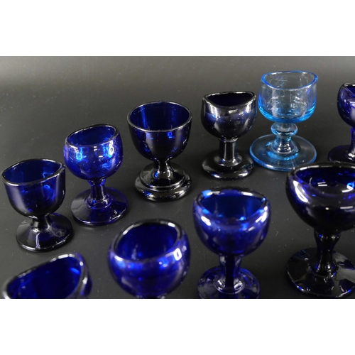 838 - Eighteen blue glass eye baths, some hand blown