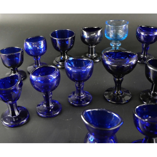 838 - Eighteen blue glass eye baths, some hand blown