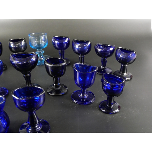 838 - Eighteen blue glass eye baths, some hand blown