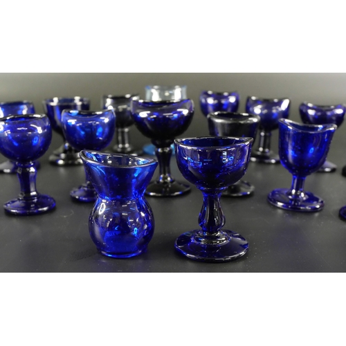 838 - Eighteen blue glass eye baths, some hand blown