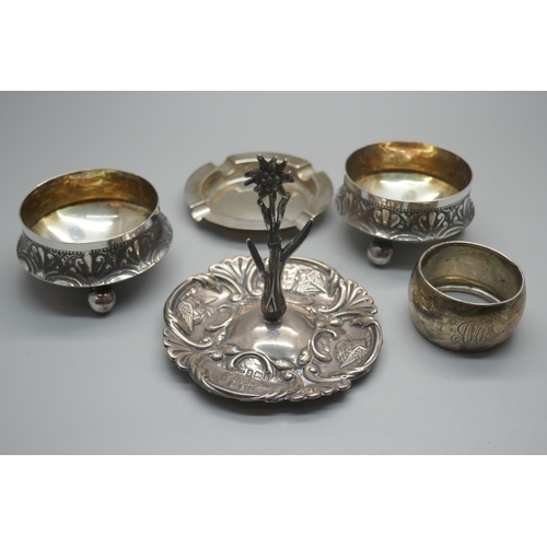 905 - A silver Reynolds Angels ring stand, Birmingham 1907, a silver ashtray, a silver napkin ring and a p... 