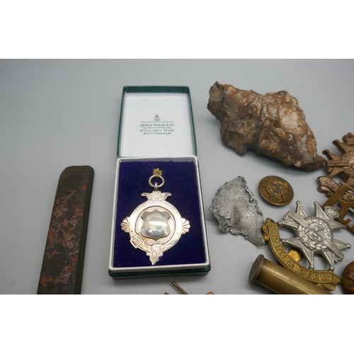 962 - Military cap badges, a piece of schrapnel and a silver fob medal