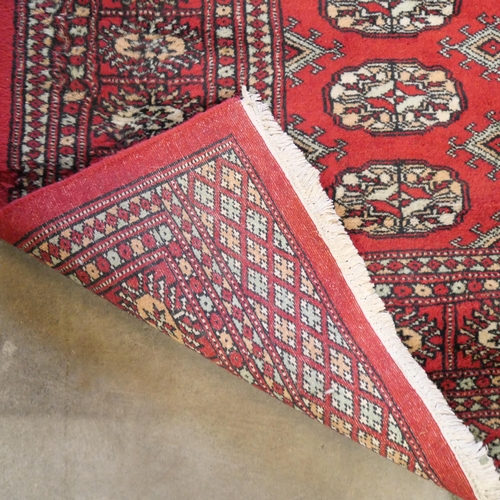 210 - A vintage eastern Bokhara red ground rug