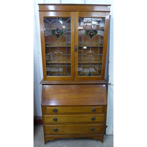 253 - An Edward VII walnut bureau bookcase with Art Nouveau stained glass doors