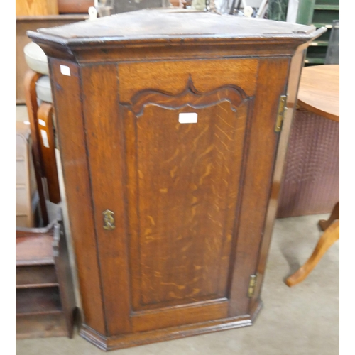 182 - An George III oak splay front wall hanging corner cupboard