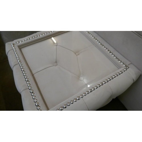 1527 - A cream three seater sofa bed and glass topped coffee table