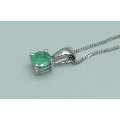 1083 - A 10ct white gold and emerald pendant on chain, 1.6g, chain 43cm