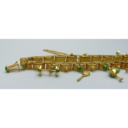 1107 - A yellow metal and jade set bracelet with badminton related charms, marked 14k, 16.5g