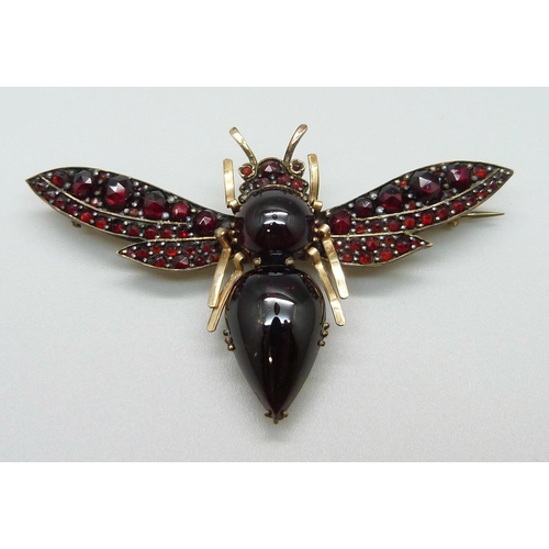 1119 - A large garnet set insect brooch, 62mm wide