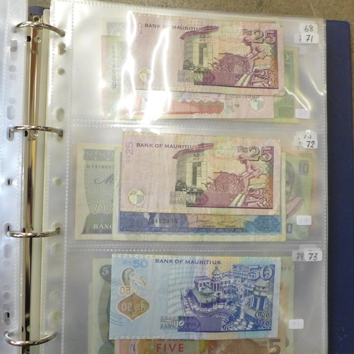 762 - A blue album of circulated bank notes, Maruitius, Singapore, Zambia, etc.