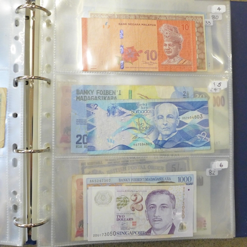 762 - A blue album of circulated bank notes, Maruitius, Singapore, Zambia, etc.