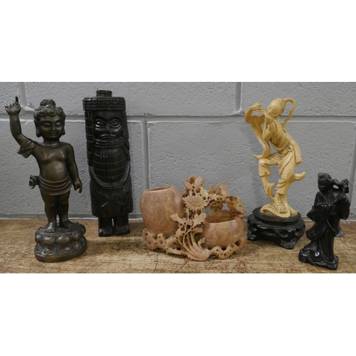 834 - A soapstone carving, an African carved wooden figure, a bronze Tibetan figure and two other figures