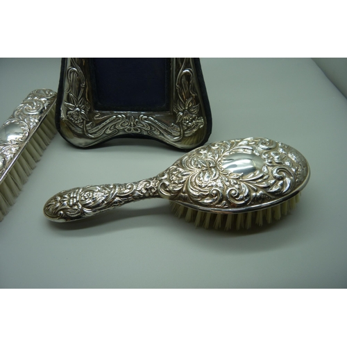 882 - Two silver backed brushes and a silver photograph frame