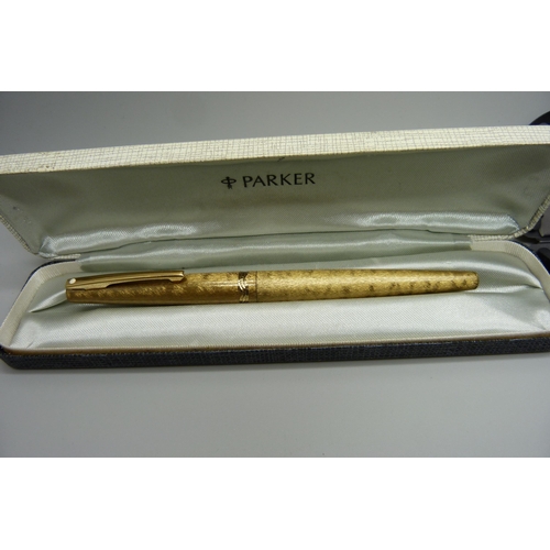 905 - A gold plated Sheaffer fountain pen with a 14ct gold nib, personalised, in a Parker case, and a Park... 