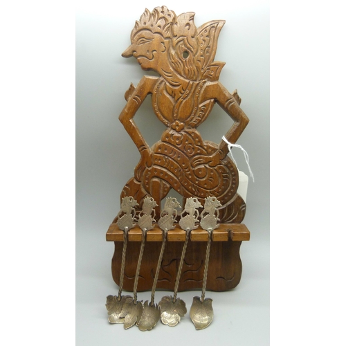 941 - A set of five Eastern .800 silver spoons in a carved wooden display rack