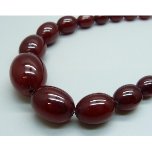 975 - A long sherry amber bead necklace, 61.3g, 40cm