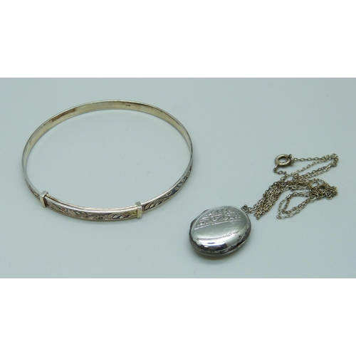 996 - A silver bangle and a 'silver back & front' locket with chain