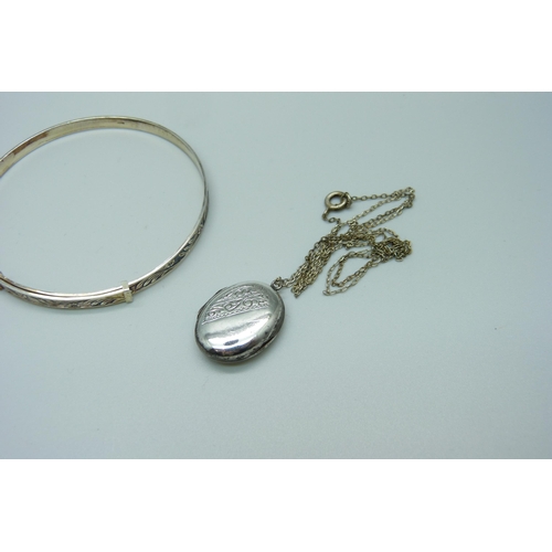 996 - A silver bangle and a 'silver back & front' locket with chain