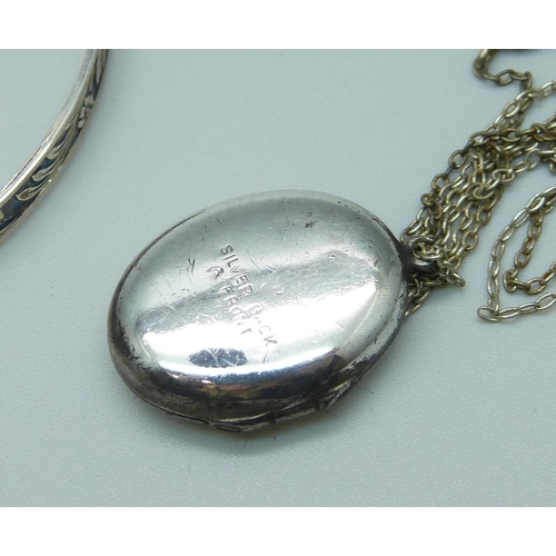 996 - A silver bangle and a 'silver back & front' locket with chain