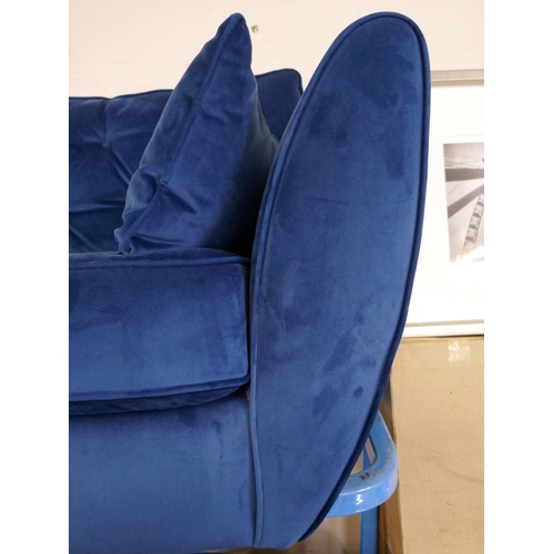 1607 - A blue velvet three seater sofa, armchair and footstool - damaged