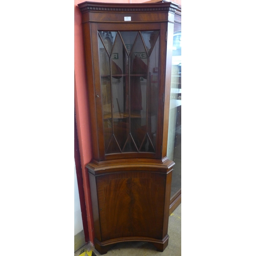 100 - A Regency style mahogany freestanding concave corner cabinet