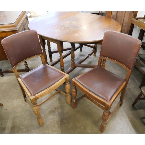 166 - An oak gateleg table and two chairs