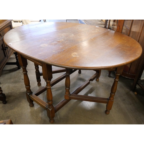 166 - An oak gateleg table and two chairs