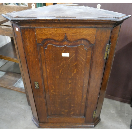 182 - An George III oak splay front wall hanging corner cupboard