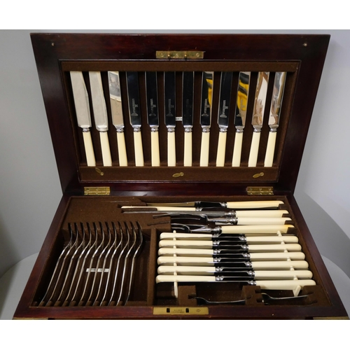 325 - An early 20th Century oak cased canteen of cutlery with faux ivory handles, including a carvery set,... 