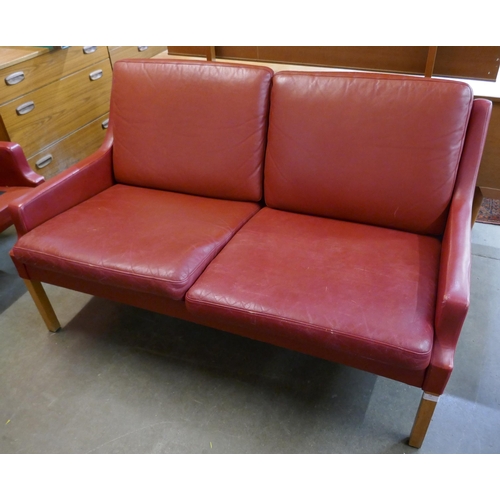 58 - A Danish Thams crimson leather two seater sofa, designed by Rud Thygesen