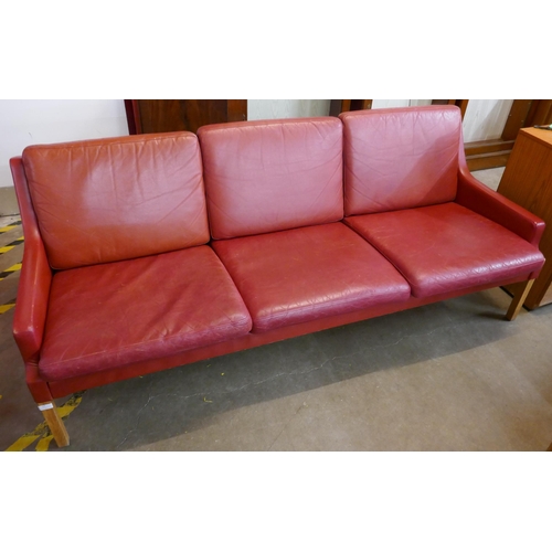 59 - A Danish Thams crimson leather three seater sofa, designed by Rud Thygesen