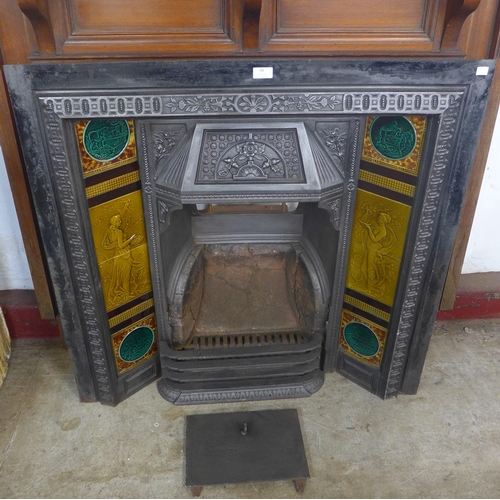 94 - An Edward VII walnut chimney-piece with tiled back cast iron fire surround