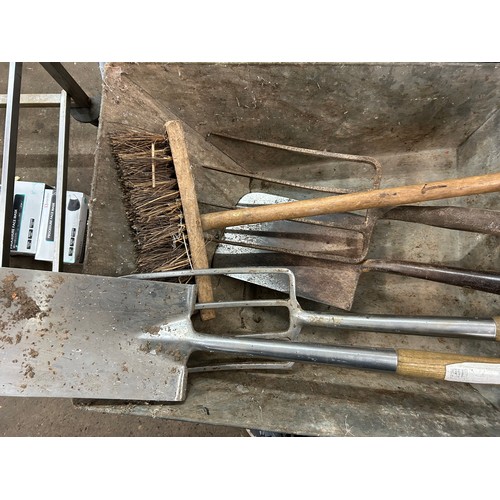 2032A - A wheelbarrow, an assortment of garden tools including two spades, two pitch forks and a stiff brist... 