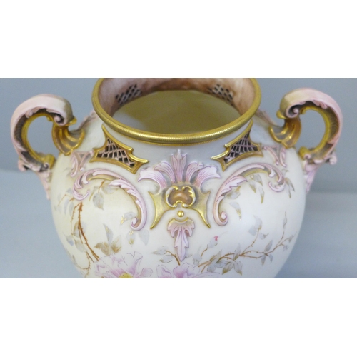 606 - A Royal Worcester scroll handled vase and cover, decorated and gilt with blossom on a shaded ivory g... 