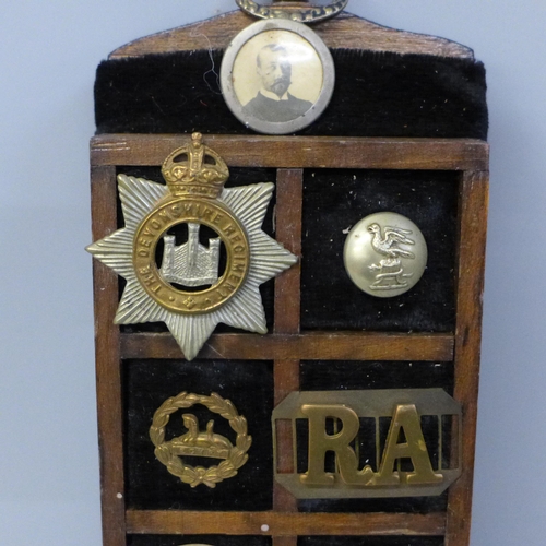 624 - A display of early 20th Century regimental buttons and badges and some loose buttons