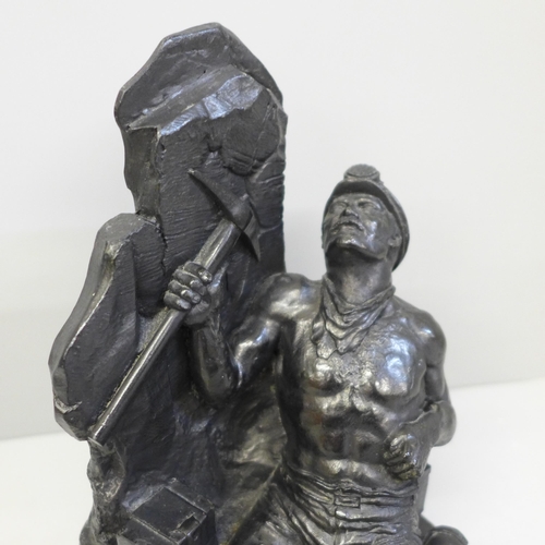 640 - A carved coal figure of a miner working at the coalface, signed and dated