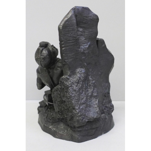 640 - A carved coal figure of a miner working at the coalface, signed and dated