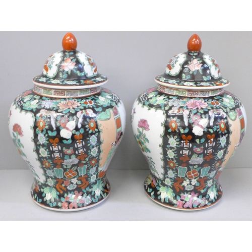 667 - A pair of Chinese porcelain famille verte jars with covers, 27cm