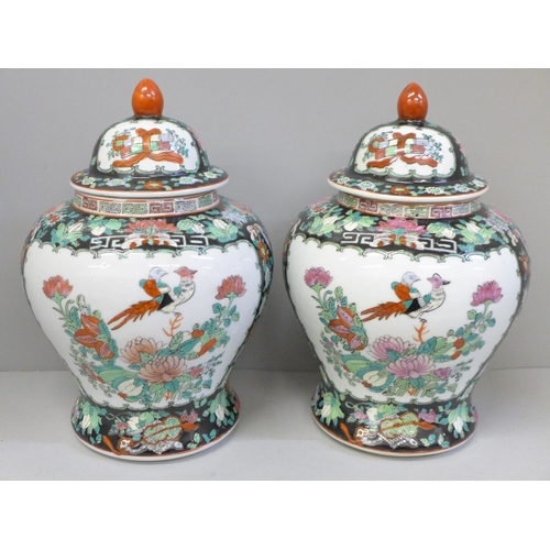 667 - A pair of Chinese porcelain famille verte jars with covers, 27cm