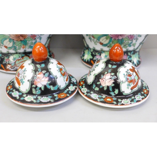 667 - A pair of Chinese porcelain famille verte jars with covers, 27cm