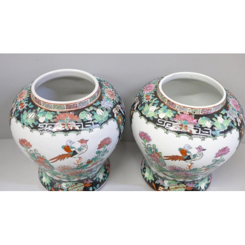 667 - A pair of Chinese porcelain famille verte jars with covers, 27cm