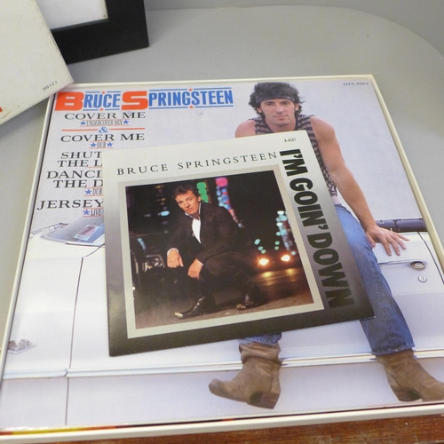 673 - A framed autographed Bruce Springsteen photograph and a boxed set of 12