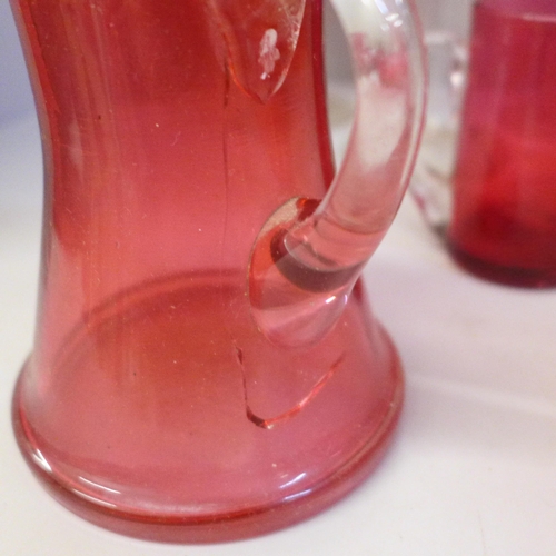 703 - Five cranberry glass wines, four cranberry glass jugs (one large), a castor and bowl **PLEASE NOTE T... 