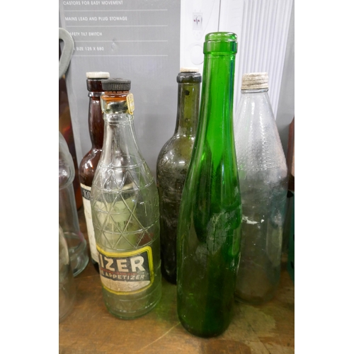 2496 - A collection of vintage bottles and tin boxes, a cast iron doorstop and a Christmas tree stand