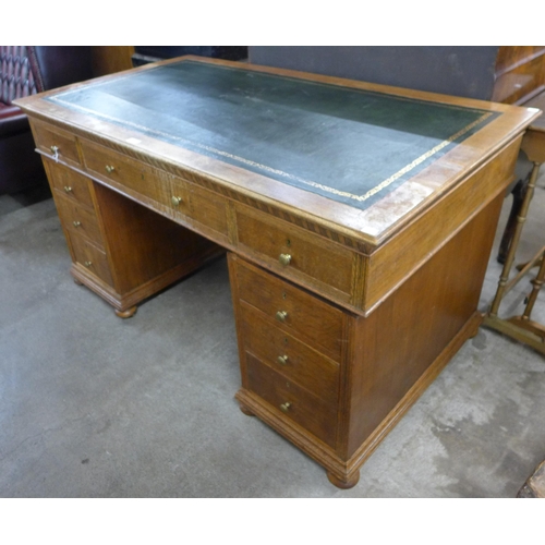 144 - A late Victorian oak and green leather topped pedestal desk