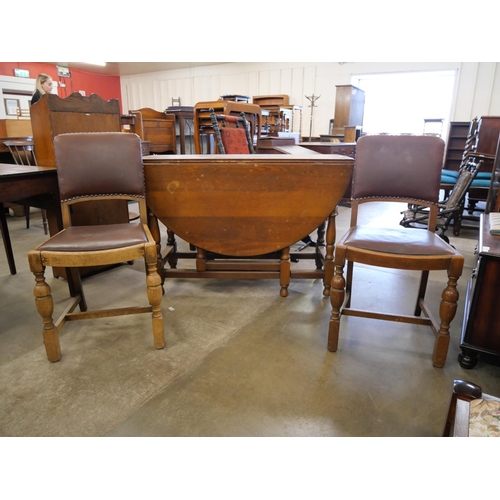 216 - An oak gateleg table and two chairs