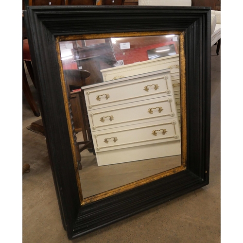 390 - An ebonised effect and parcel gilt framed mirror