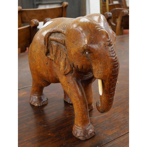 397 - An African carved wooden elephant with faux ivory tusks