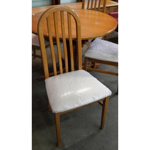 42 - A teak circular extending dining table and four chairs