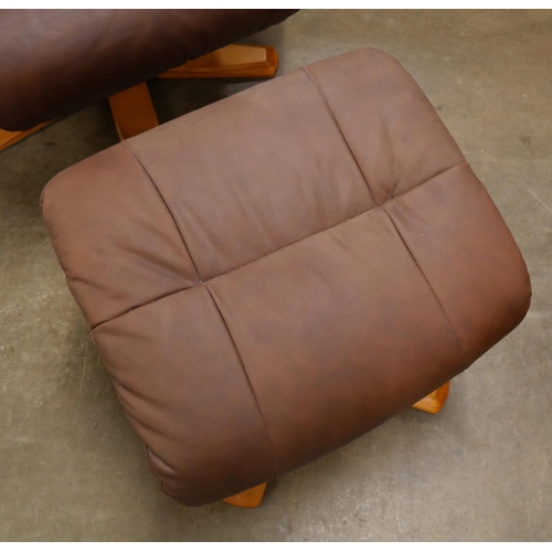 57 - A beech and brown leather revolving armchair and stool